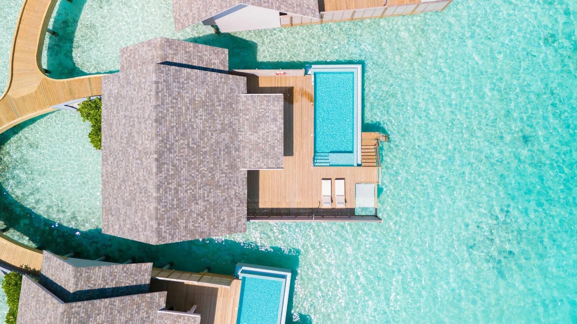 A Water Pool Villa's plunge pool seen directly from above, wooden walkways threading between overwater villas