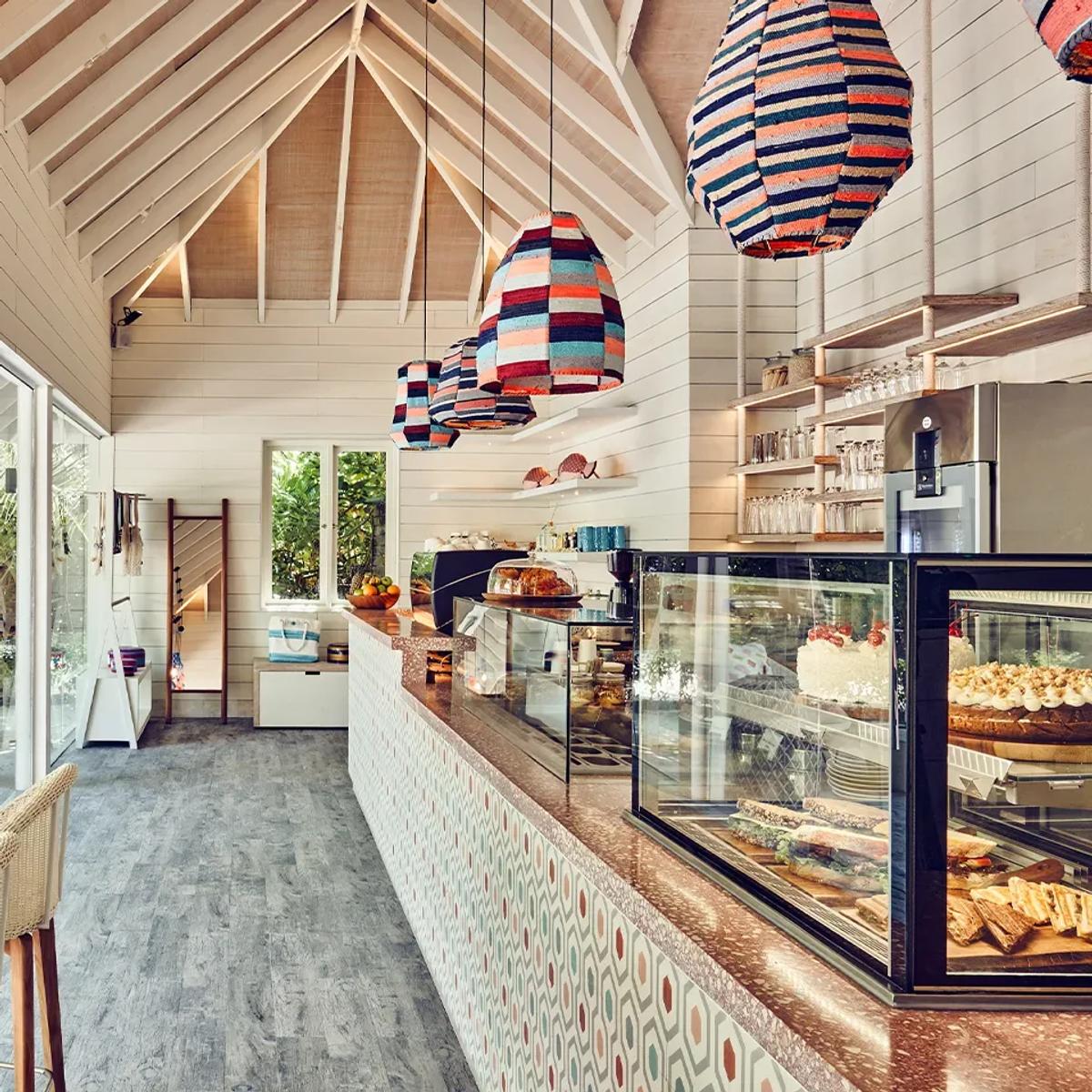Milk LAB's counter hung with colourful woven pendant lights, its display case stocked with cakes and sandwiches