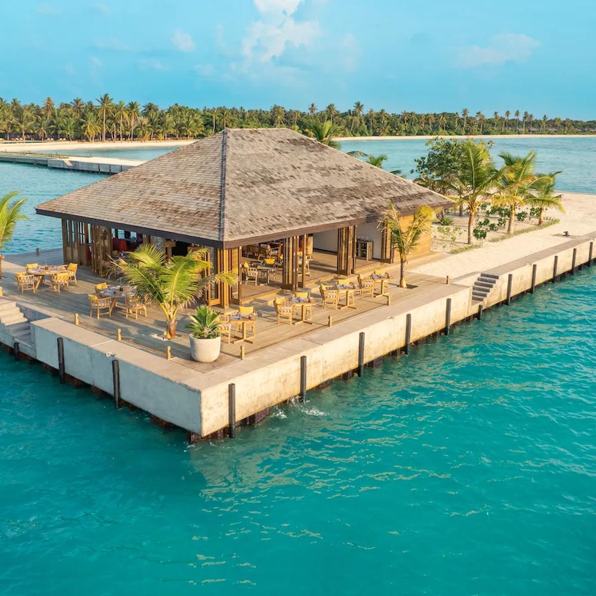 Molo Restaurant and Bar's overwater pavilion at Mabin Island, catching the light at sunset