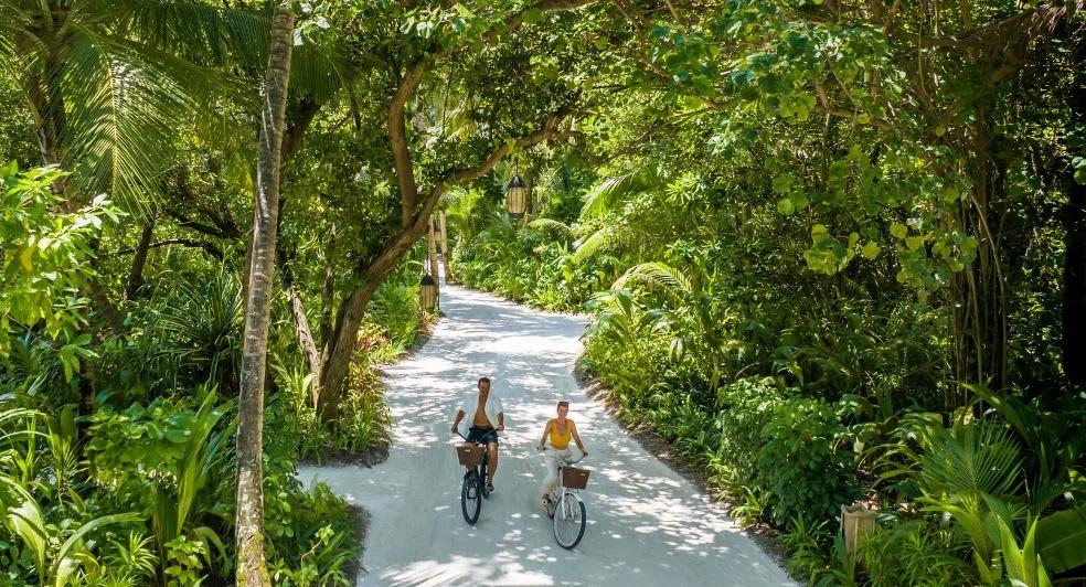 Guests walking one of Niyama's resort paths between the two islands