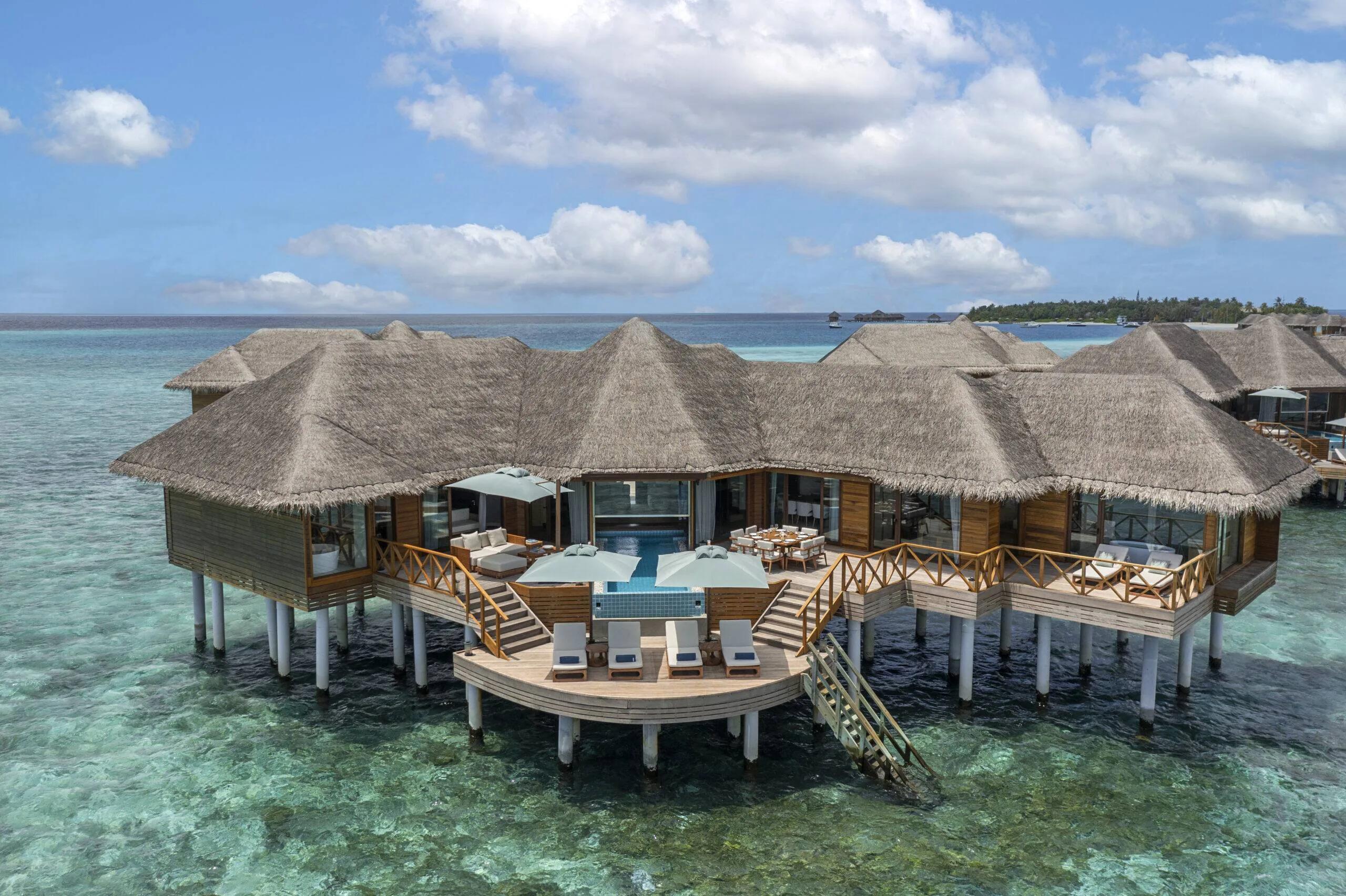 Aerial view of a Two-Bedroom Ocean Pavilion, its thatched roof and circular deck plunge pool set apart from the main villa row