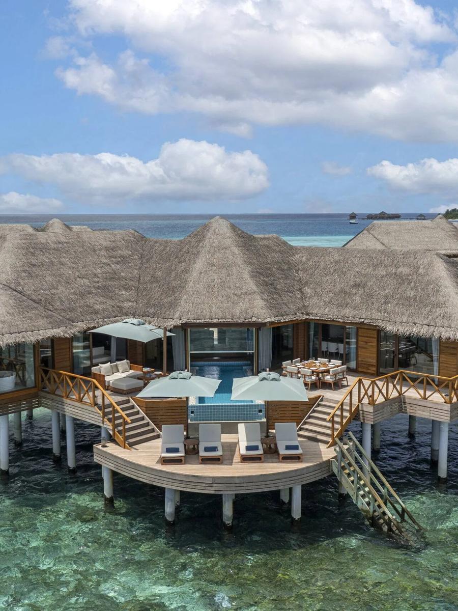 Aerial view of a Two-Bedroom Ocean Pavilion, its thatched roof and circular deck plunge pool set apart from the main villa row