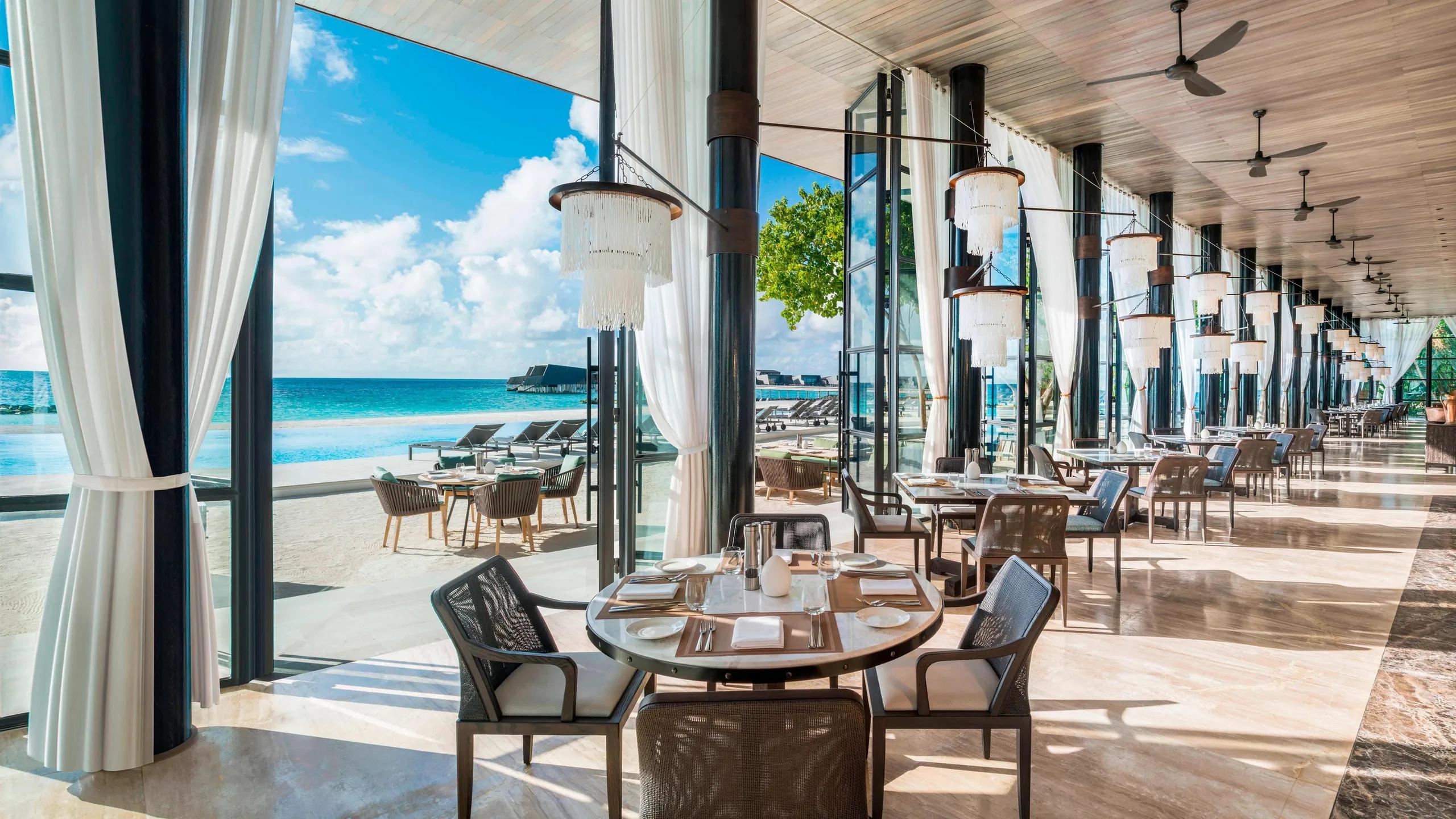 The high-ceiling, sea-view interior of ALBA, the resort's signature all-day restaurant
