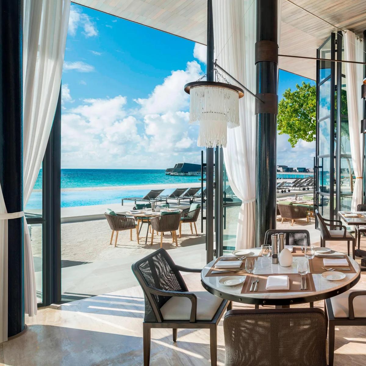 The high-ceiling, sea-view interior of ALBA, the resort's signature all-day restaurant