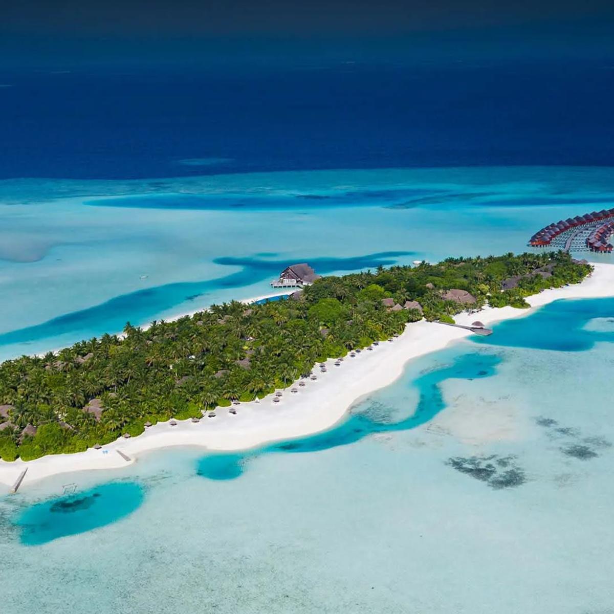 Aerial view of Anantara Dhigu Maldives Resort on Dhigufinolhu Island, South Malé Atoll, ringed by lagoon and reef
