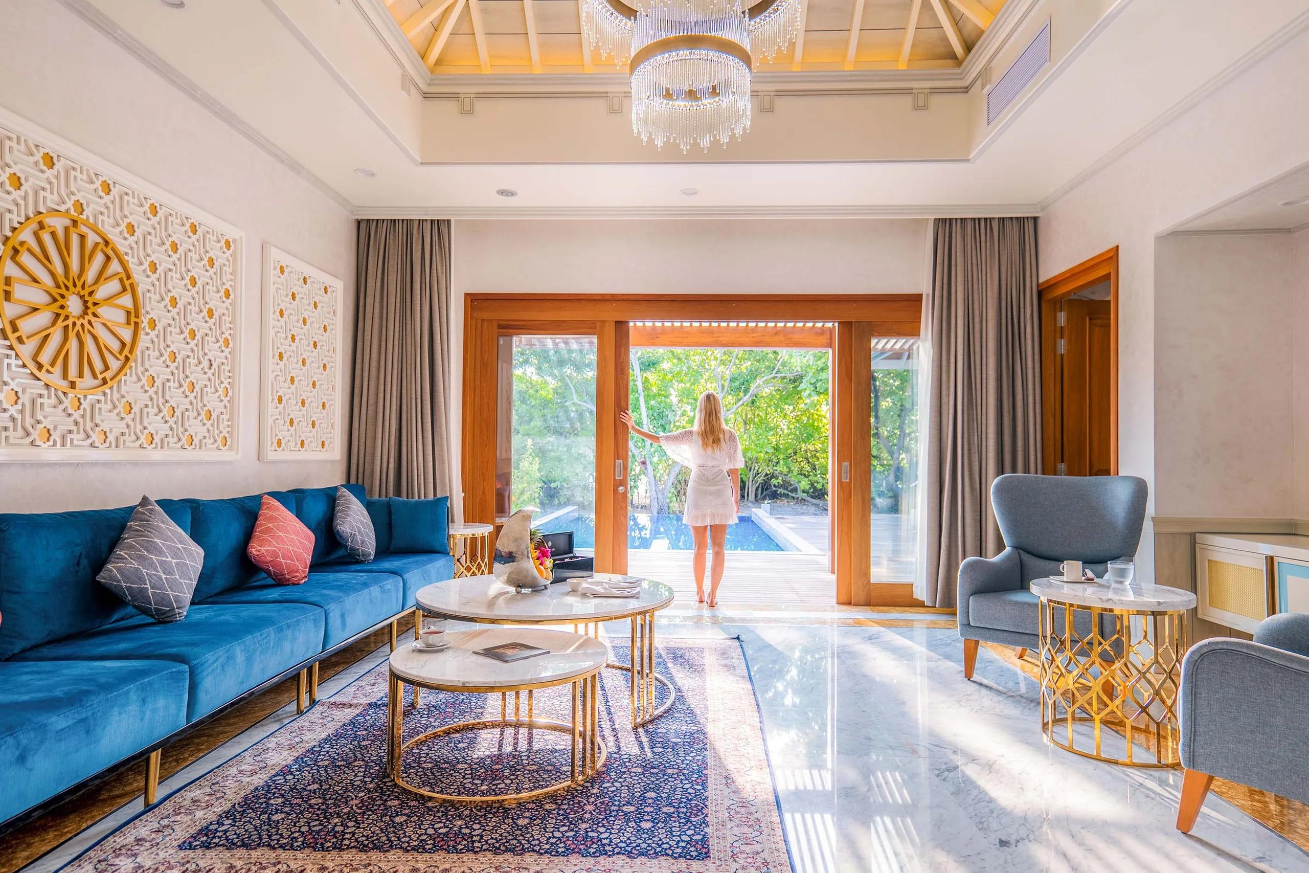 Living room of a Signature Beach Residence, ornate screens and a chandelier over marble floors