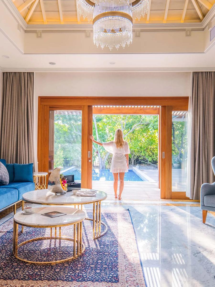 Living room of a Signature Beach Residence, ornate screens and a chandelier over marble floors