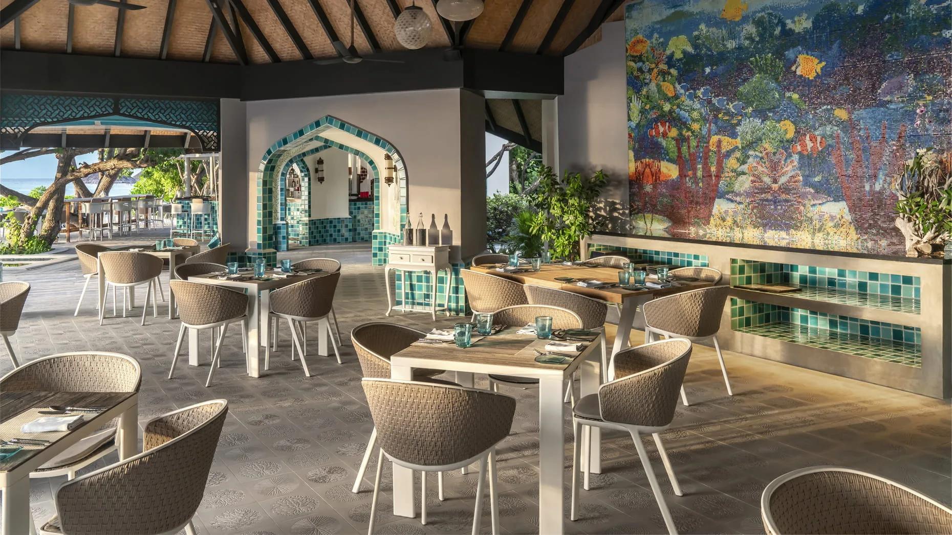Reef Club's dining room, a coral mosaic on the wall and the pool visible through the archway