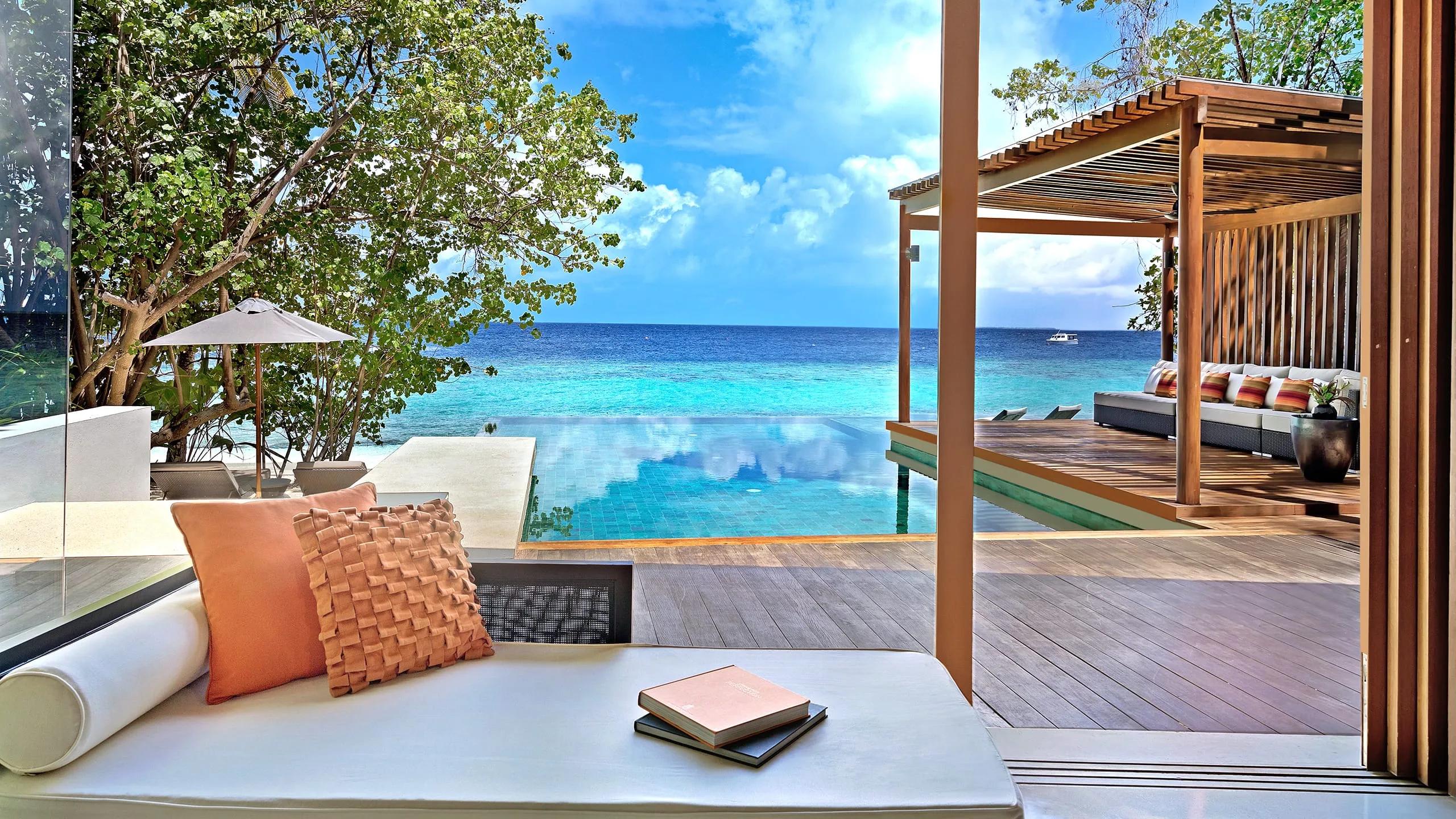 The main pavilion and pool deck of a Deluxe Beach Pool Villa, set among palm trees