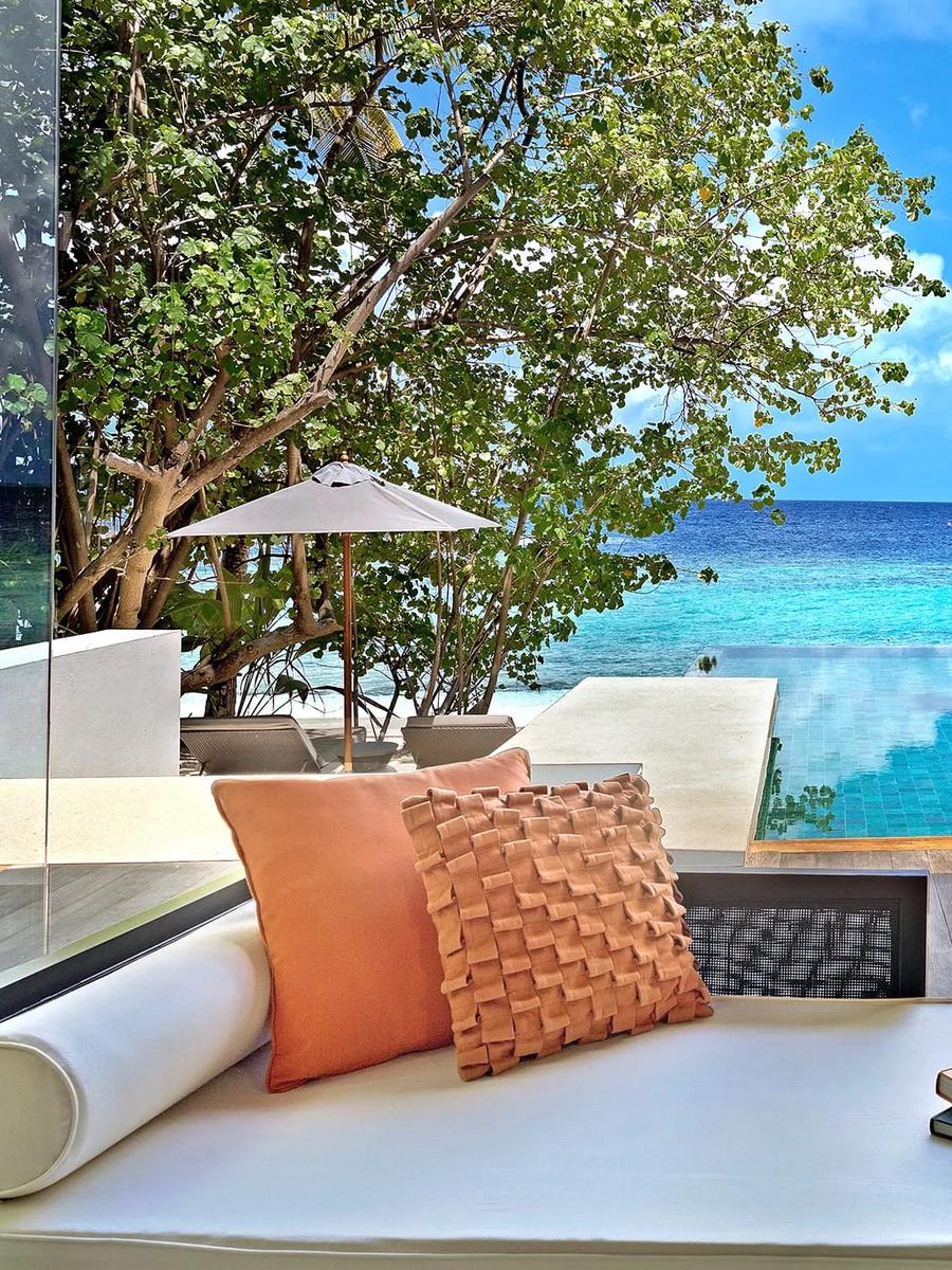 The main pavilion and pool deck of a Deluxe Beach Pool Villa, set among palm trees
