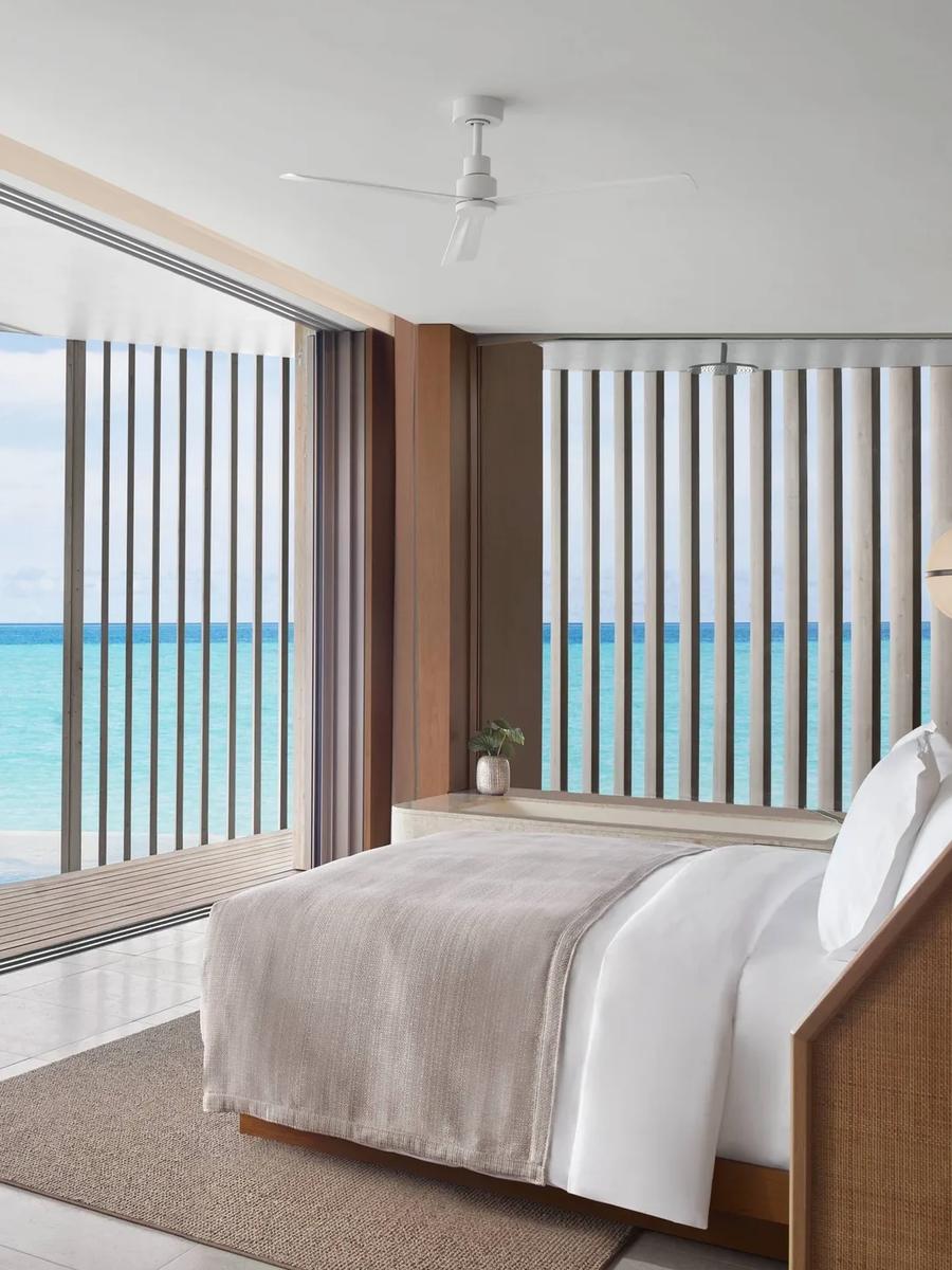 An Ocean Pool Villa bedroom opening onto a private infinity pool and the sea