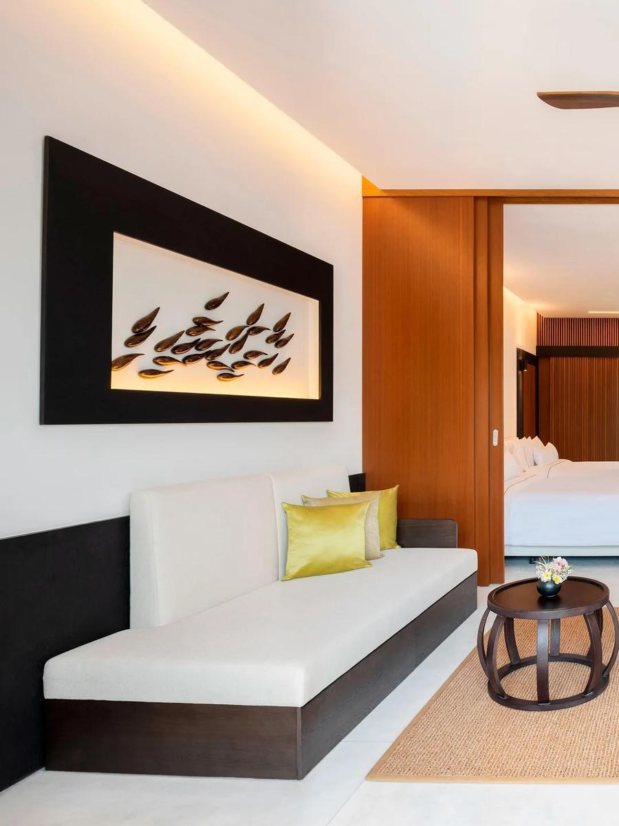 The private living room of a Two-Bedroom Villa with Pool, sliding wood doors open to the bedroom beyond