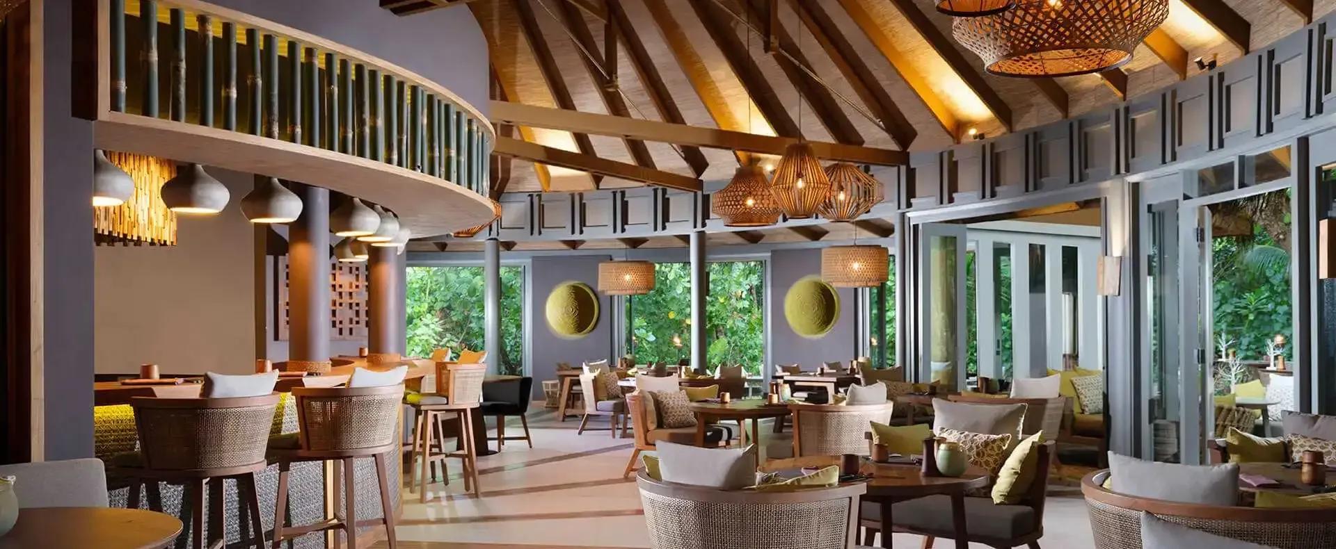 Interior of Onu's bamboo-domed dining pavilion, an open kitchen and dining counter set beneath woven ceiling lanterns