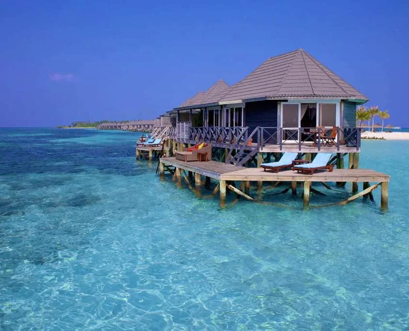 A row of Sangu Water Villas on stilts over the lagoon, loungers out on the overwater deck