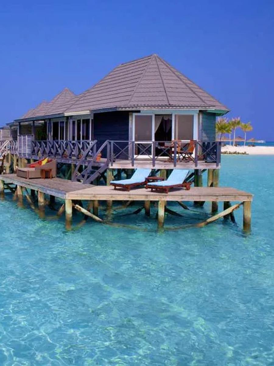 A row of Sangu Water Villas on stilts over the lagoon, loungers out on the overwater deck