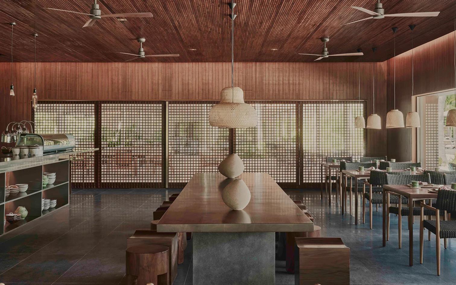 The dining room at Wok Society, wood-panelled and screened from the garden by latticed doors