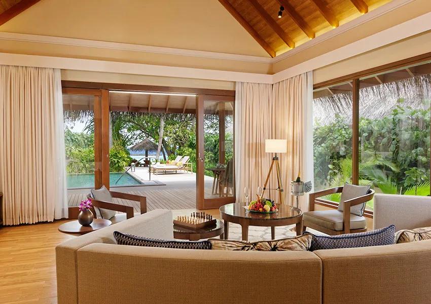 The Baros Residence's private pool deck at sunset, sun loungers facing directly out over the open ocean