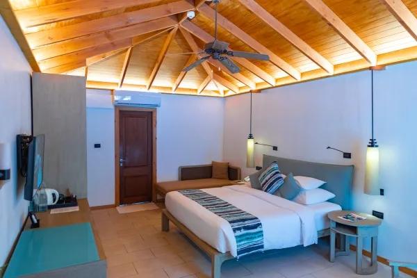 Adjacent Beachfront Villa bedroom, with an exposed wood-beam ceiling and bench seating