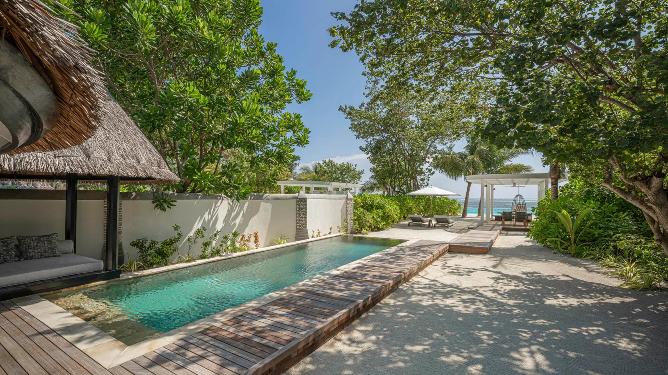 A Sunrise Family Beach Villa's pool and walkway to the beach in morning light