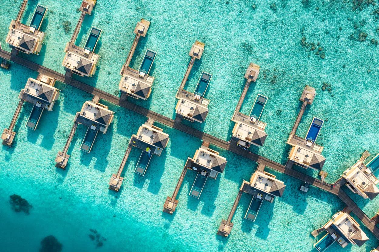 Aerial view of In-Ocean Pool Villas reaching out over the lagoon at Angsana Velavaru