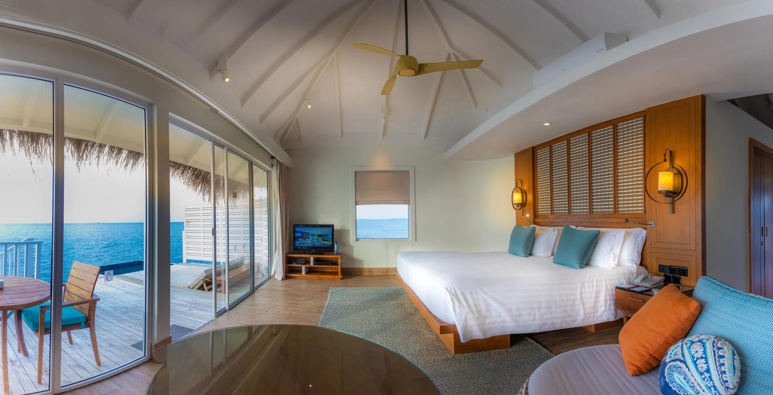 The vaulted thatched ceiling and wooden fan of a Sunset Overwater Villa's living area