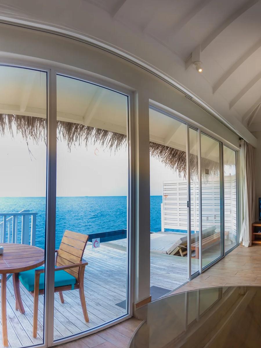 The vaulted thatched ceiling and wooden fan of a Sunset Overwater Villa's living area
