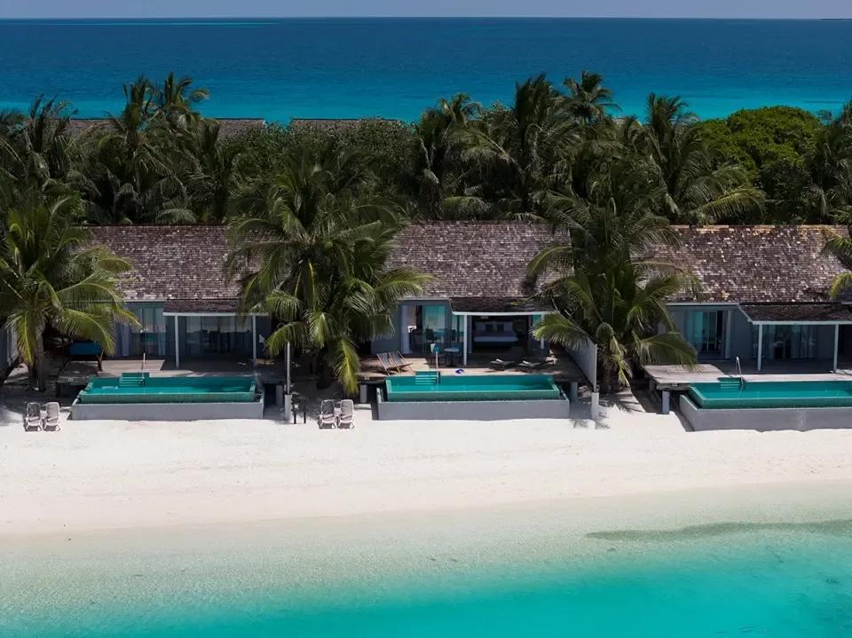 Three Pool Villas set behind a stretch of beach, each with its own tiled private pool, seen from an elevated angle