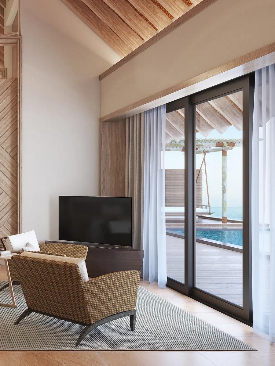 The bedroom of an Overwater Villa at Waldorf Astoria Maldives Ithaafushi, with floor-to-ceiling views of the lagoon — the Two Queen Bedded Overwater Villa has no dedicated published photo, so this sibling overwater-villa image stands in here