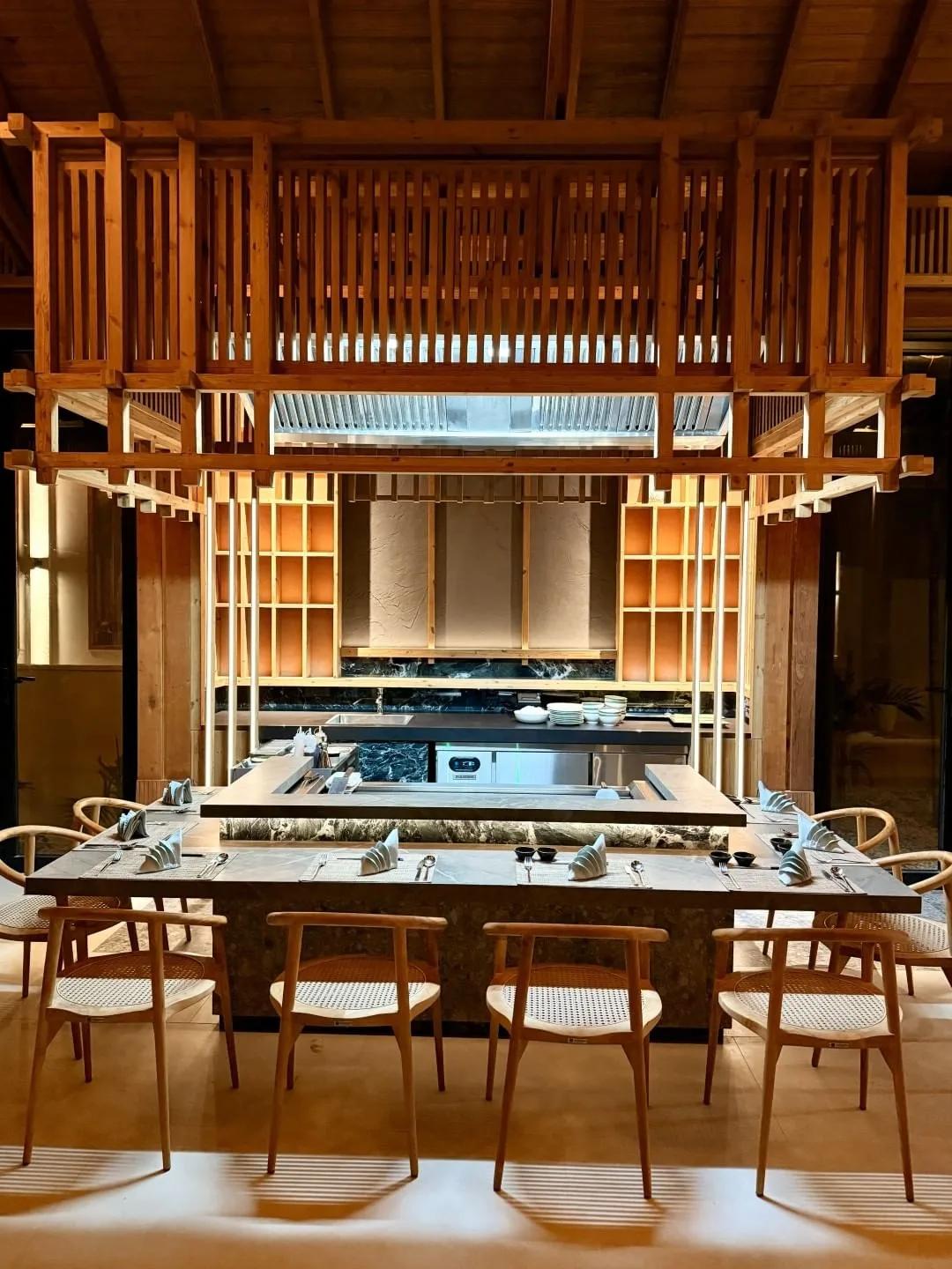 Ikigai's teppanyaki counter and open grill, set beneath a timber-slat mezzanine