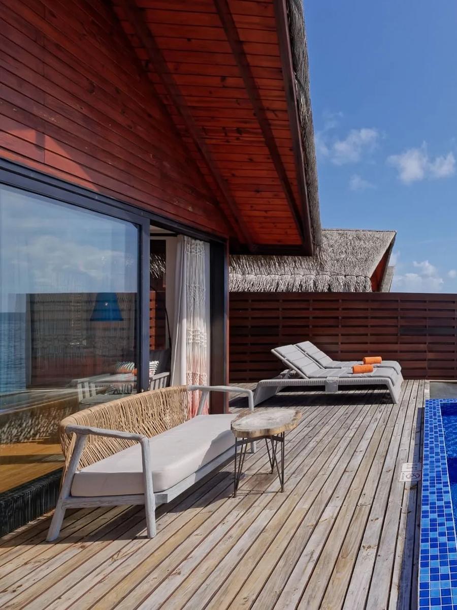 The deck of a Reef Pool Water Villa in daylight, set over the house reef
