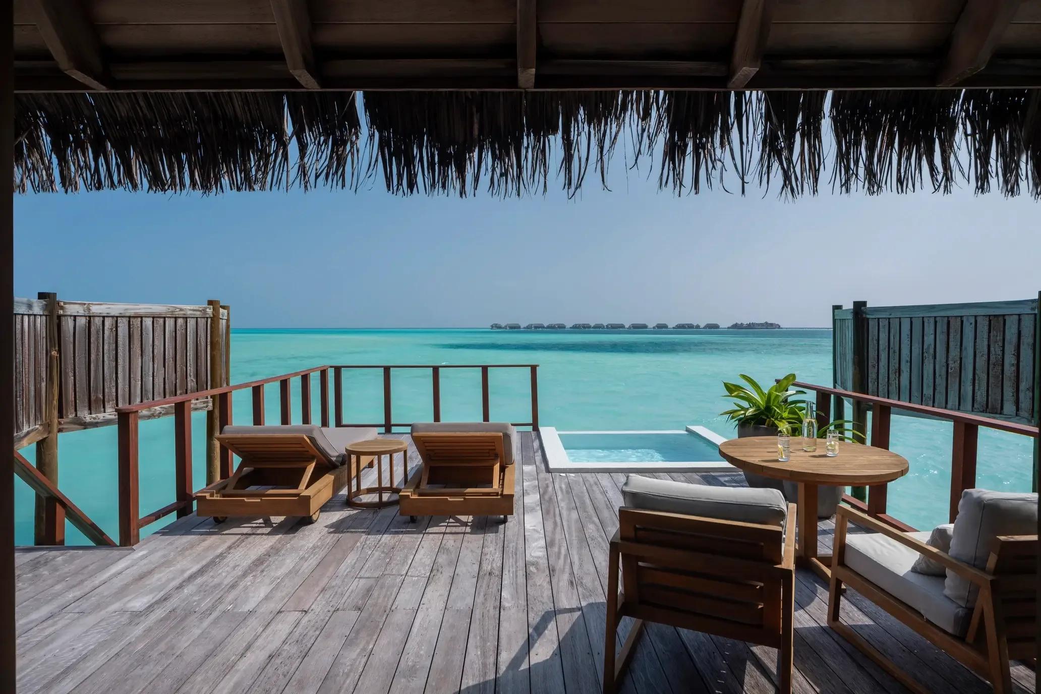 The deck of a Sunrise Water Villa over open lagoon water at Conrad Maldives Rangali