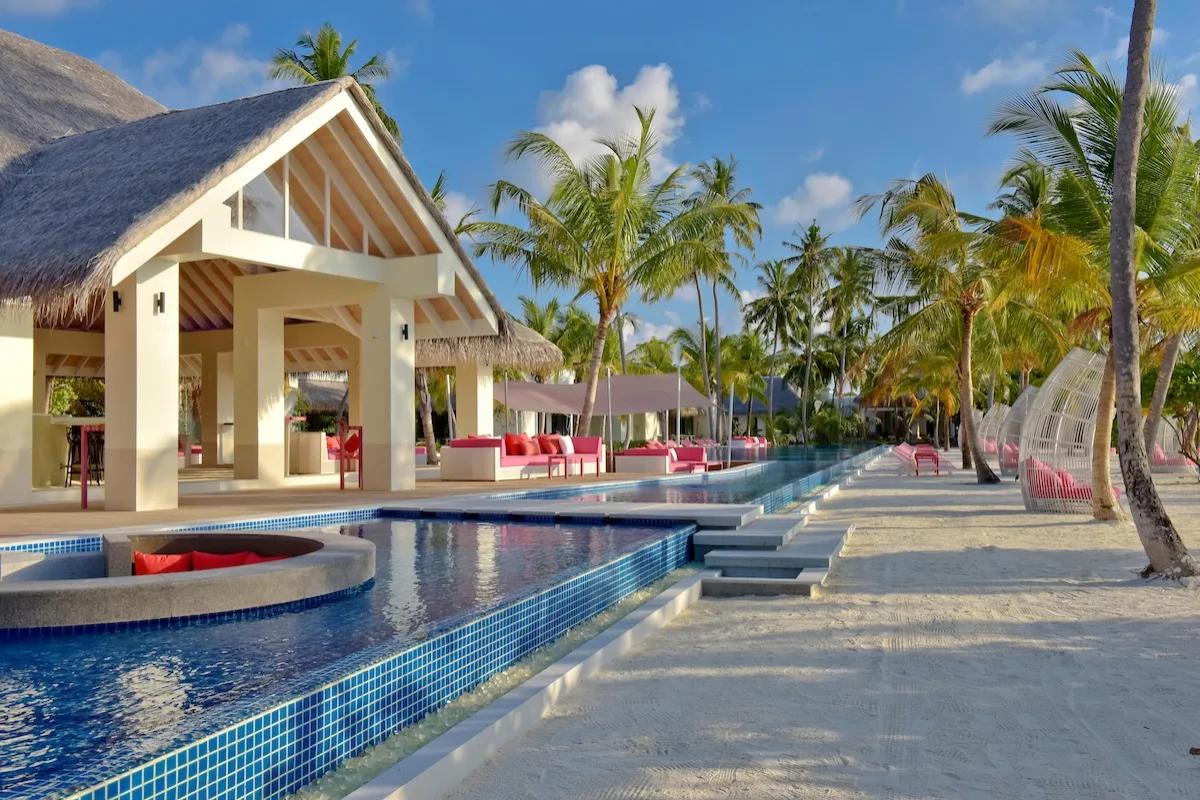 The long lap pool beside Breeze Pool Bar, with cabanas and pink loungers along its length