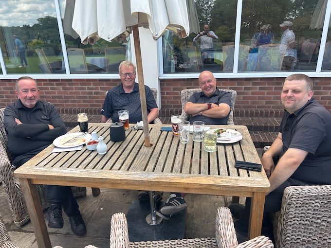 Four members around a terrace table after the round