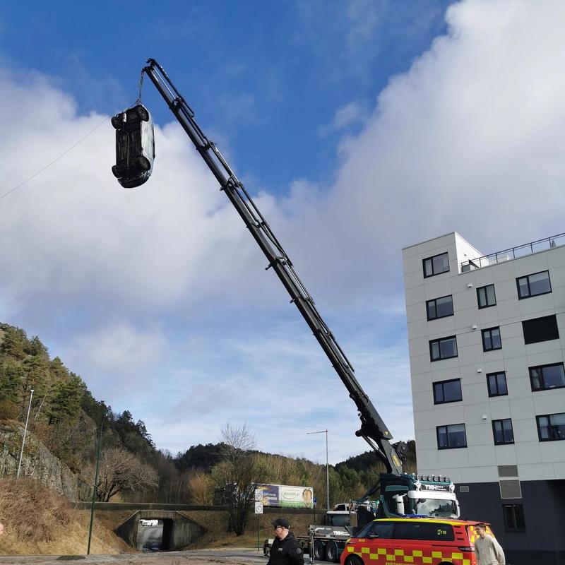 En lastebil holder opp en bil 30 meter over bakken i en kran. Det gjøres klart for å droppe bilen og krasje den i 60 km/t.