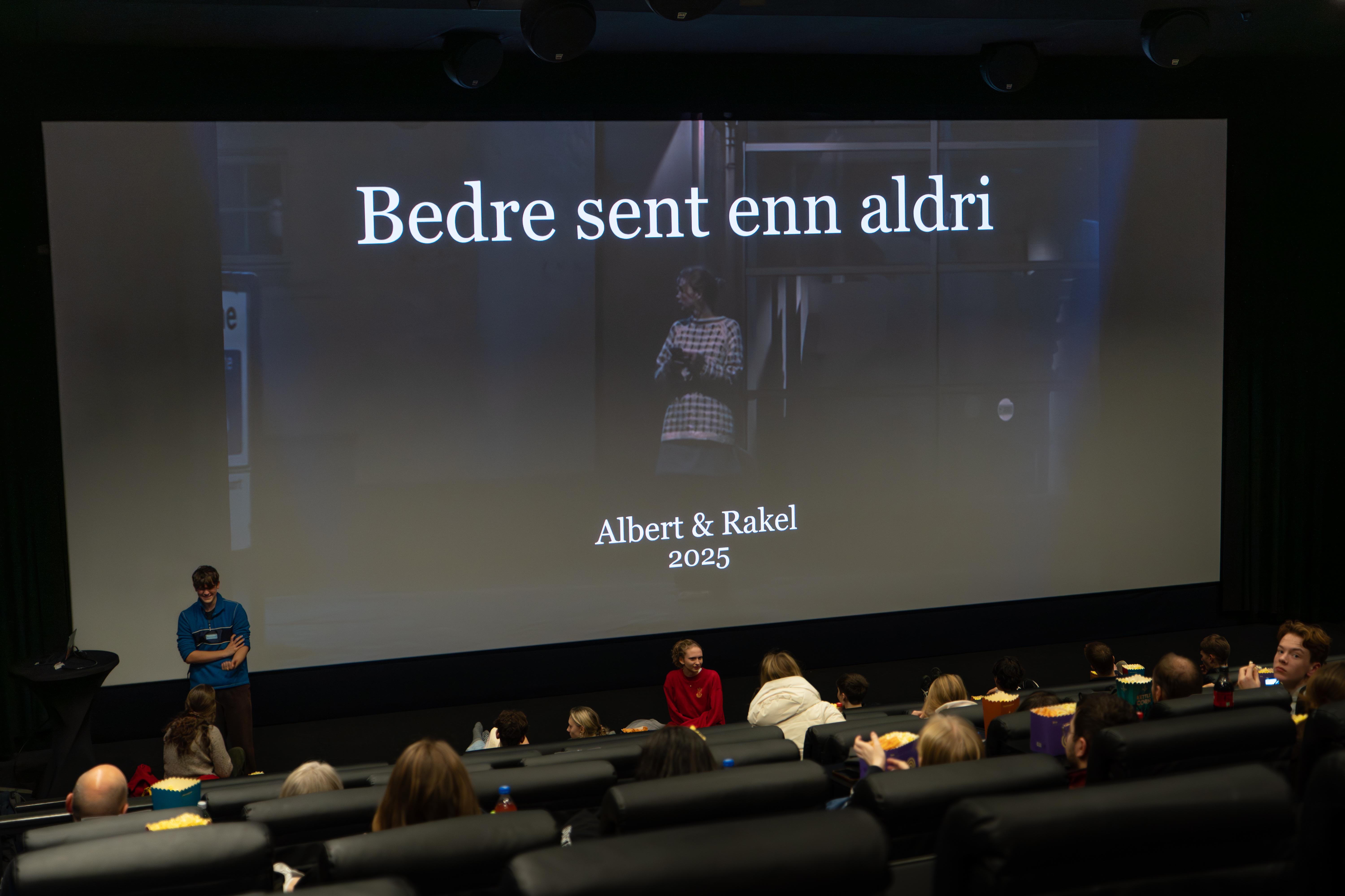 Lerret med presentasjon. Kinosal fylt med mennesker. Bergen kino
