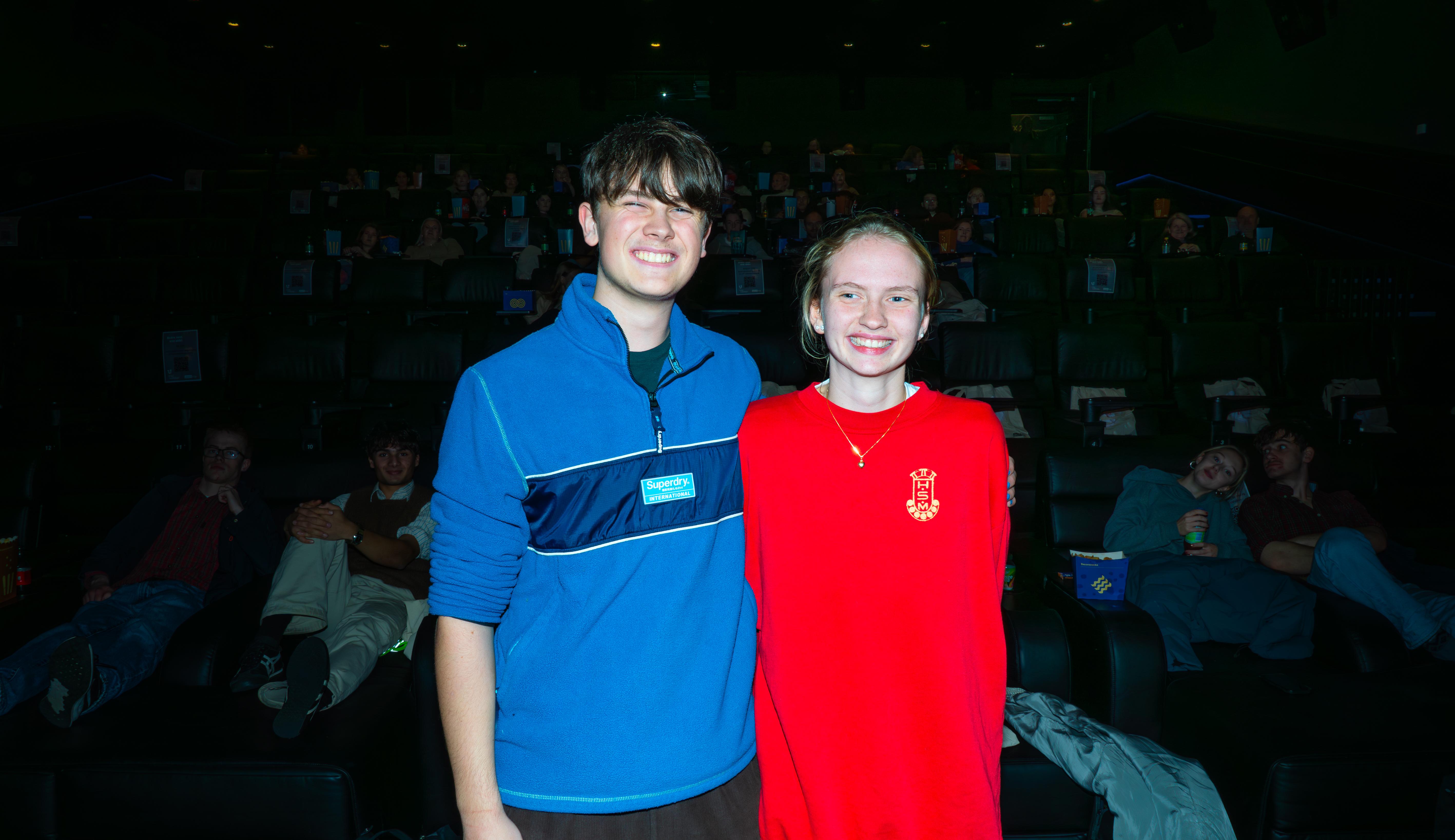 to ungdommer som smiler. Sal fylt med ungdommer og voksne på bergen kino