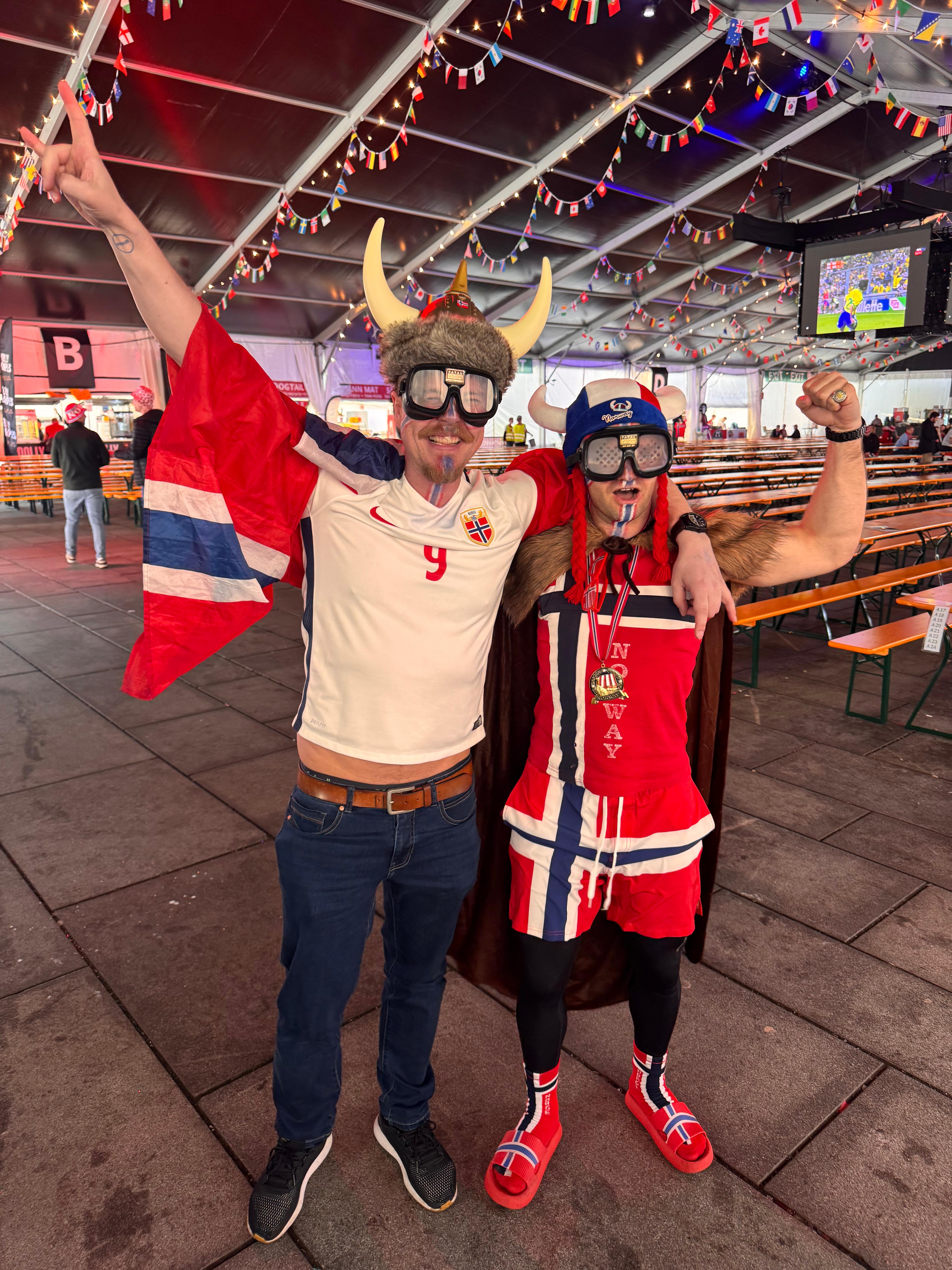 to menn i norgesdrakt og norgesflagg i bergen fotballfest