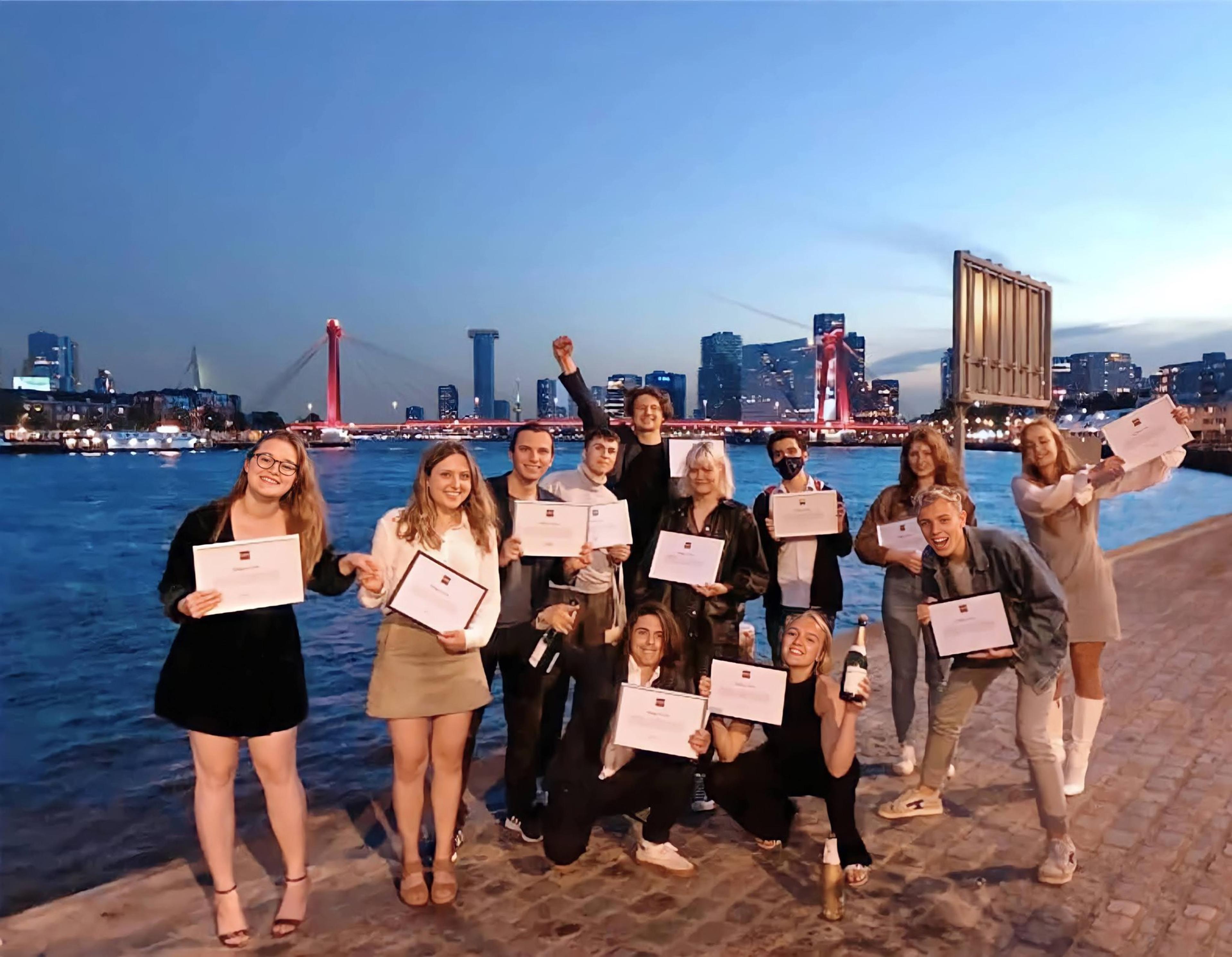 A group of young people smiling holding pledge certificates