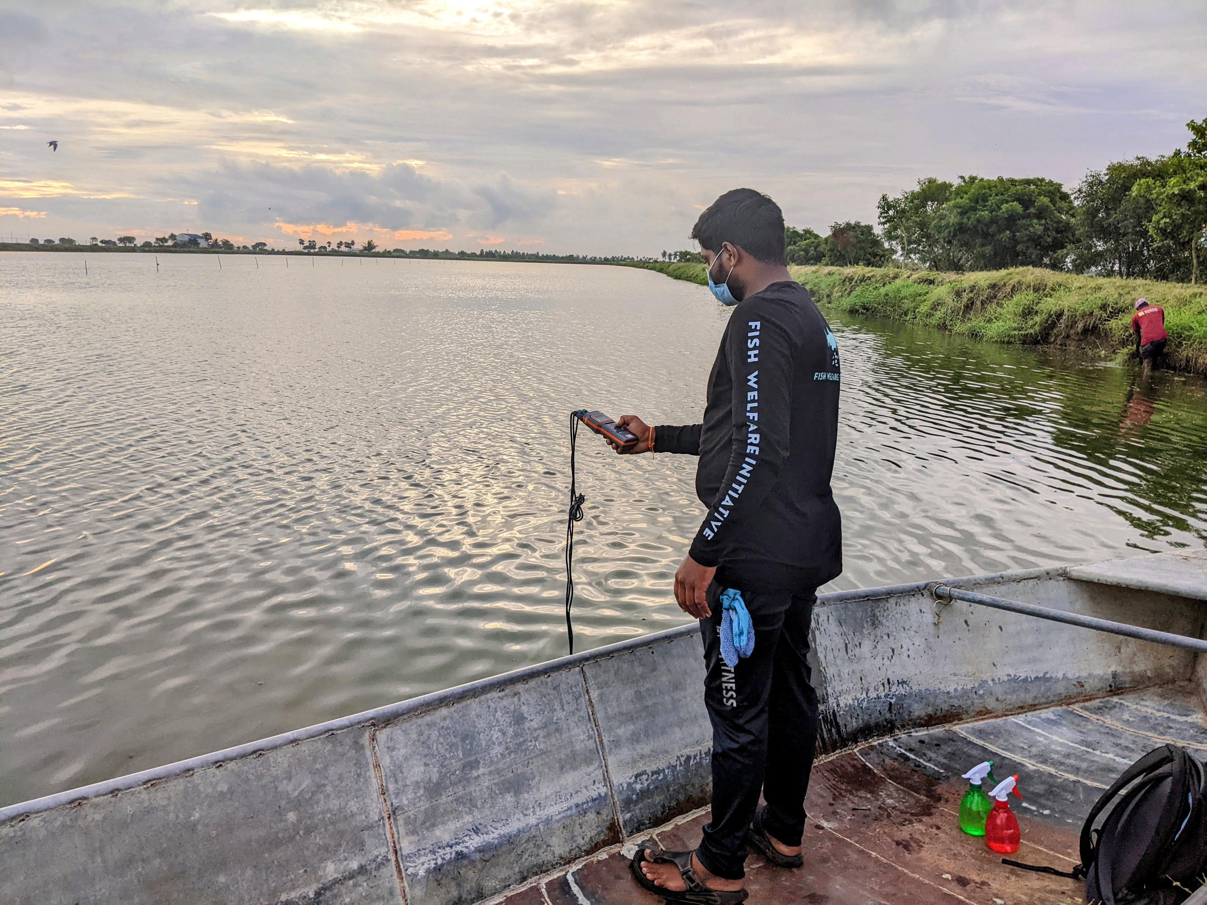 An FWI staff member collects a water quality measurement at one of the farms in FWI’s farm program in Andhra Pradesh, India.