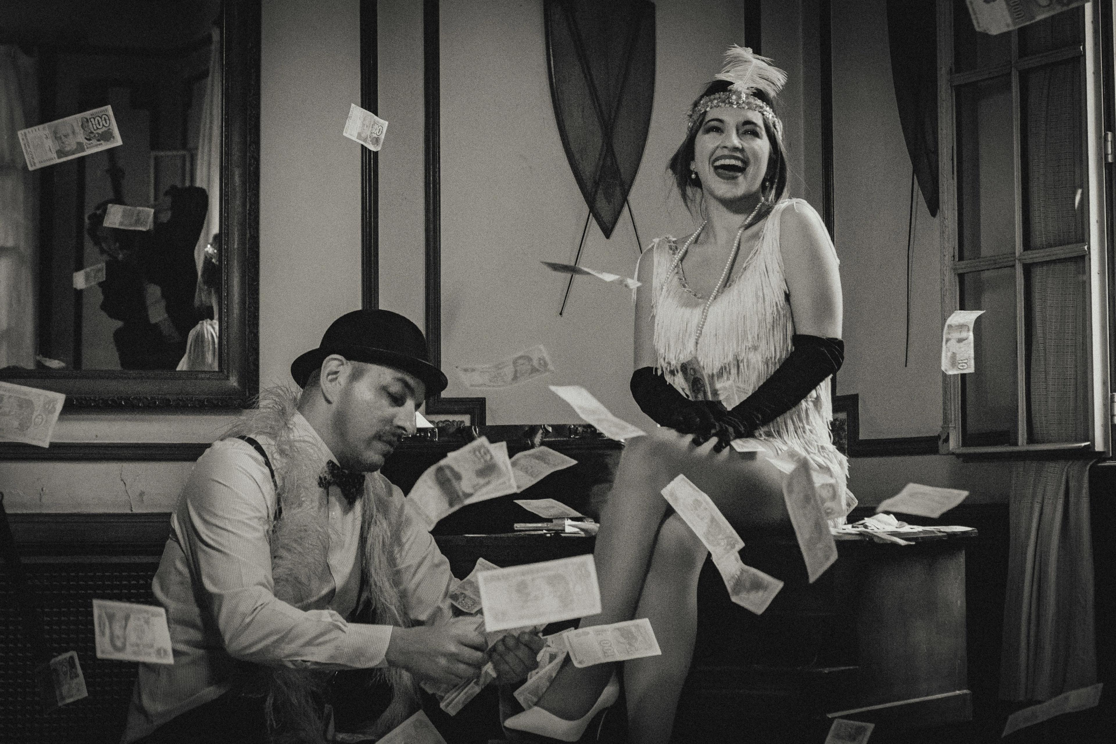 1920s couple laughing with dollar bills flying around them