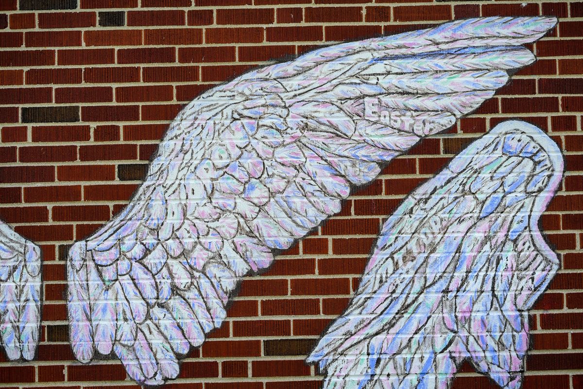 Close-up of feather linework with words hidden in the brushstrokes