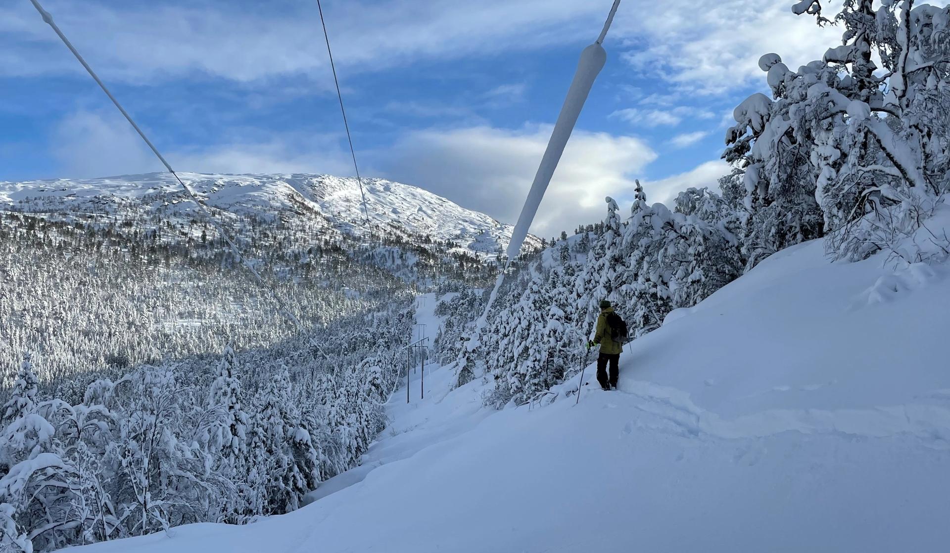 Snø i fjellet under kraftledninger