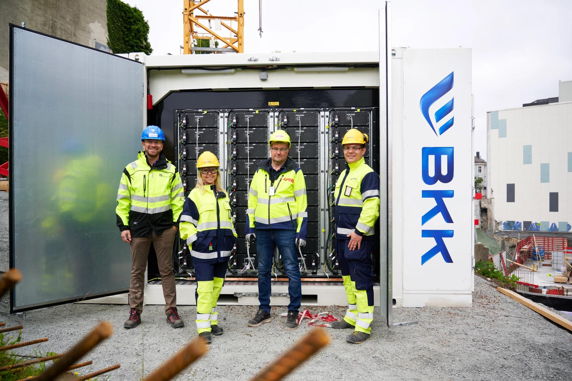 Dette 11 tonn tunge batteriet skal blant annet gi strøm til en tårnkran og byggtørking. F.v. Sturla Hjelmervik (Entra), Camilla Moster (BKK), Inge Andersen (LAB Entreprenør) og Kjetil Strand Solheim (BKK). Foto: Helge Hansen / BKK.