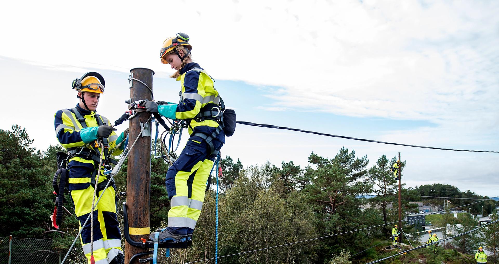 Montører arbeider i en kraftmast