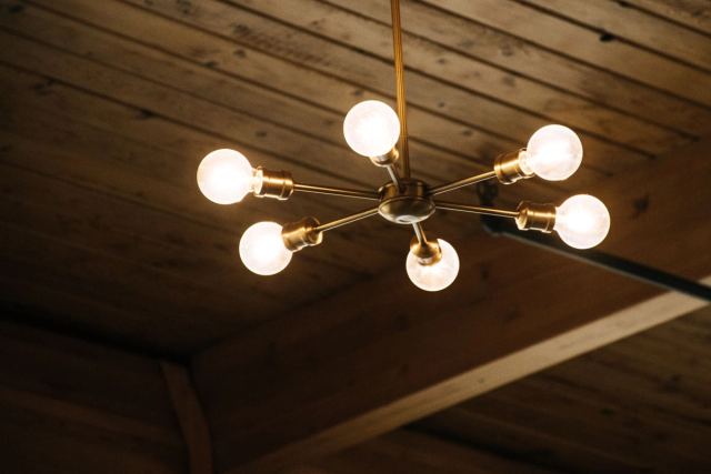 Brass sputnik chandelier against a timber-boarded ceiling