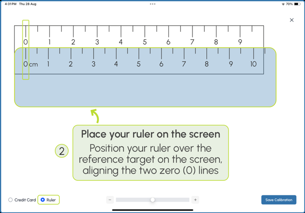 Aligning a ruler with the on-screen calibration target, matching the zero marks