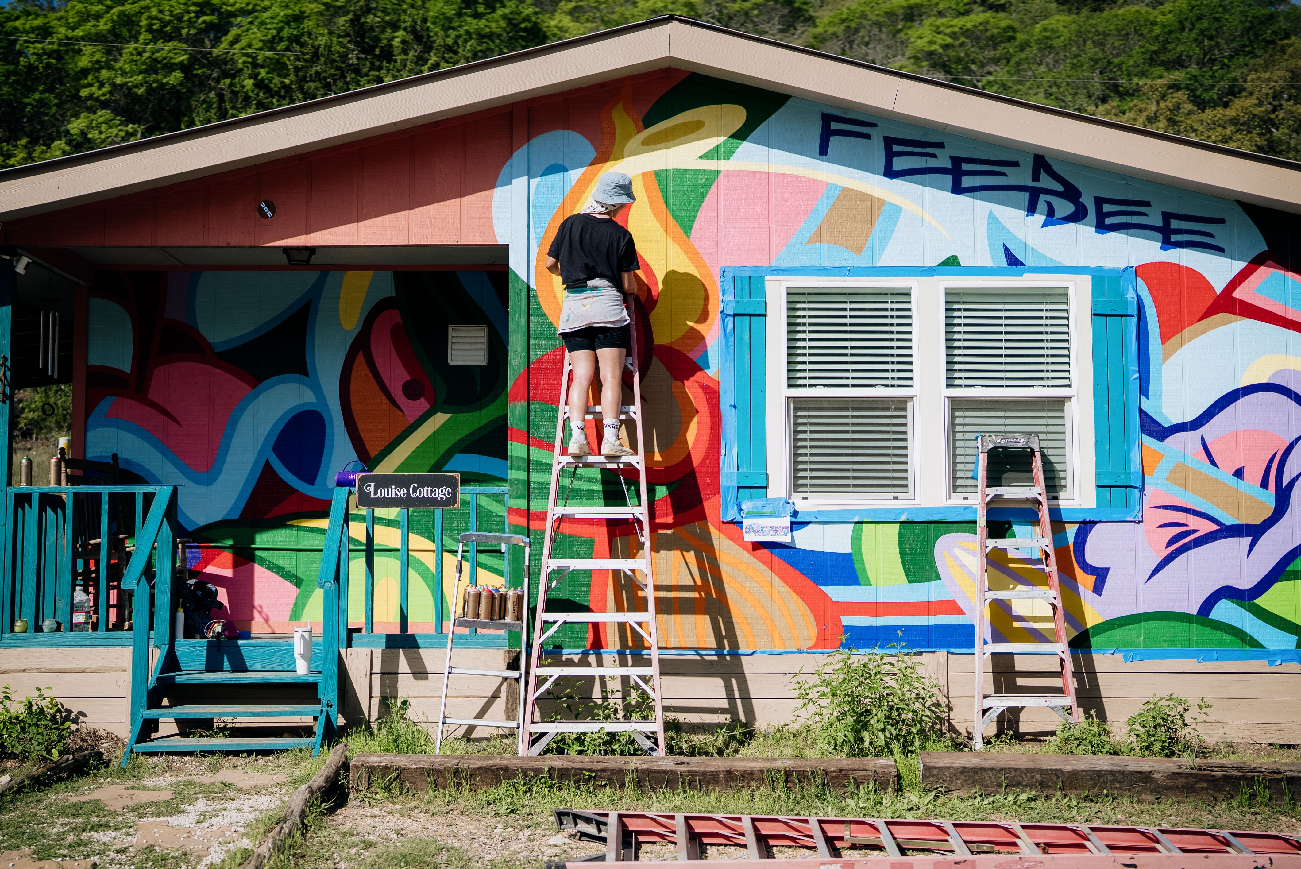 Artist FeeBee painting The Louise Cottage during the Wild Walls Artist Retreat