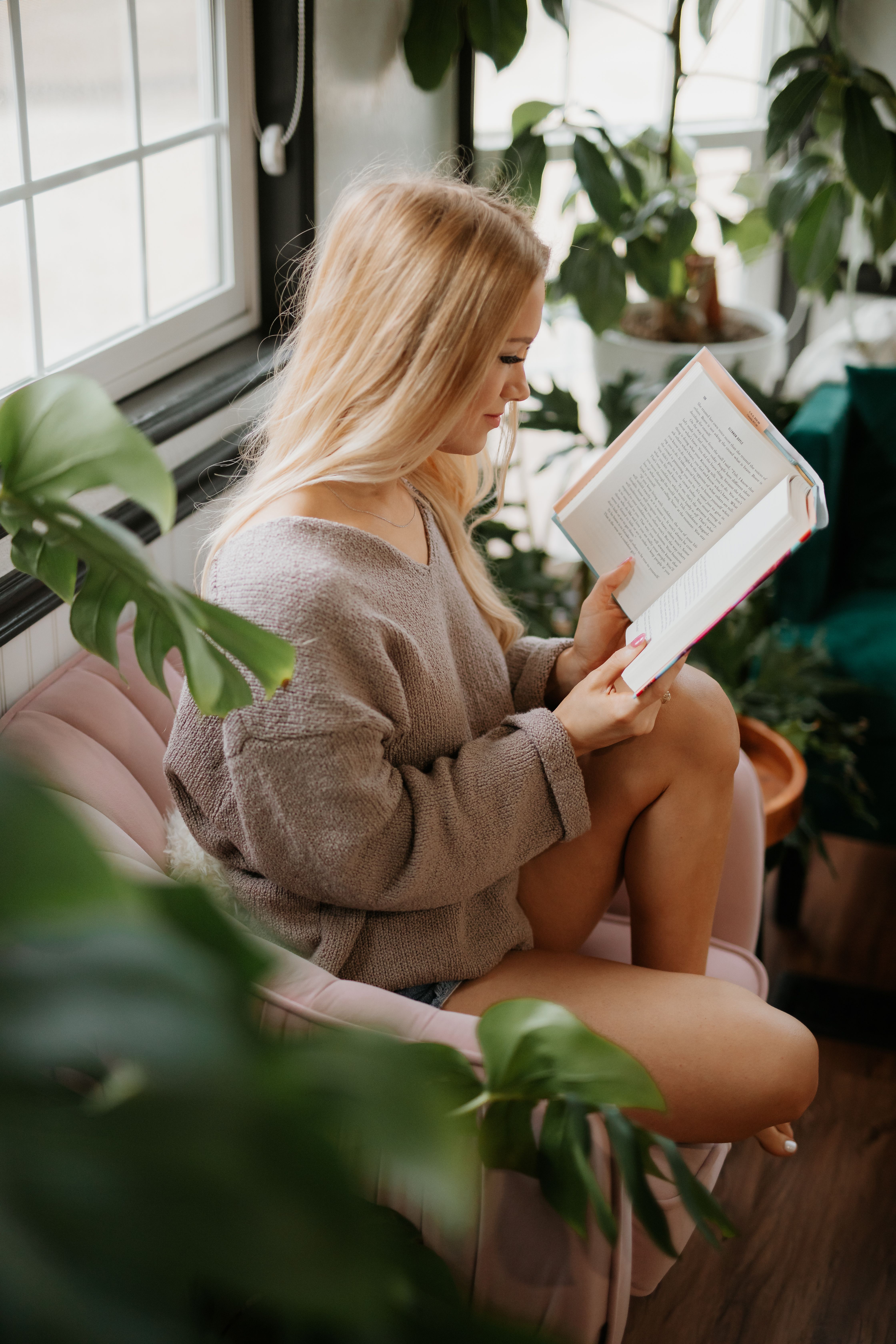 Woman reading book in the Greenhouse tiny home at The Inn Between in Concan, Texas