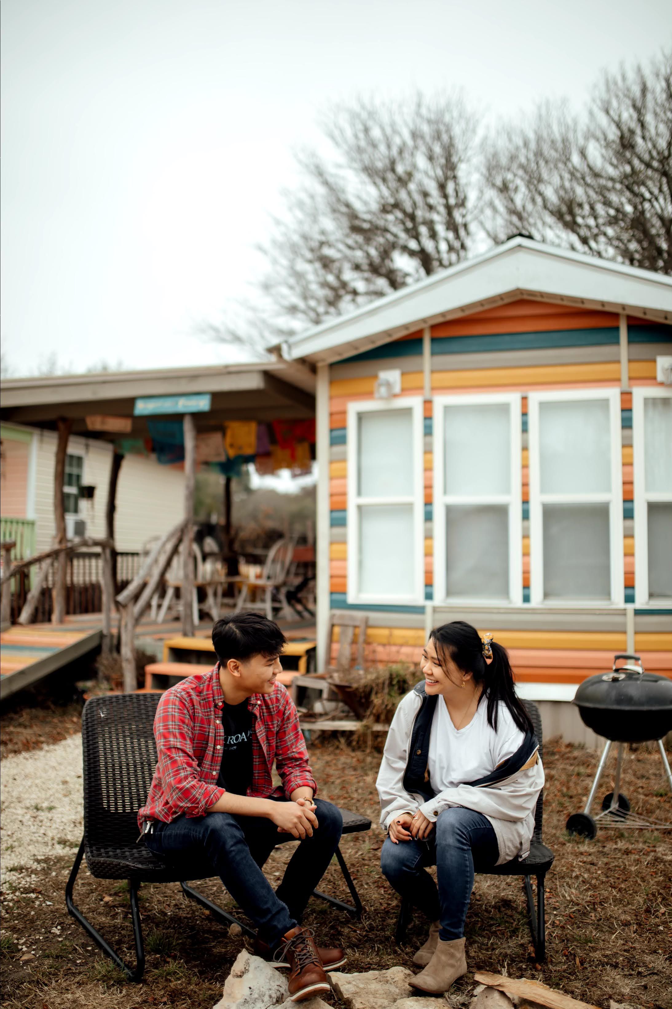 Woman and Man sitting outside of the colorful Hippies and Cowboys Tiny Home at The Inn Between