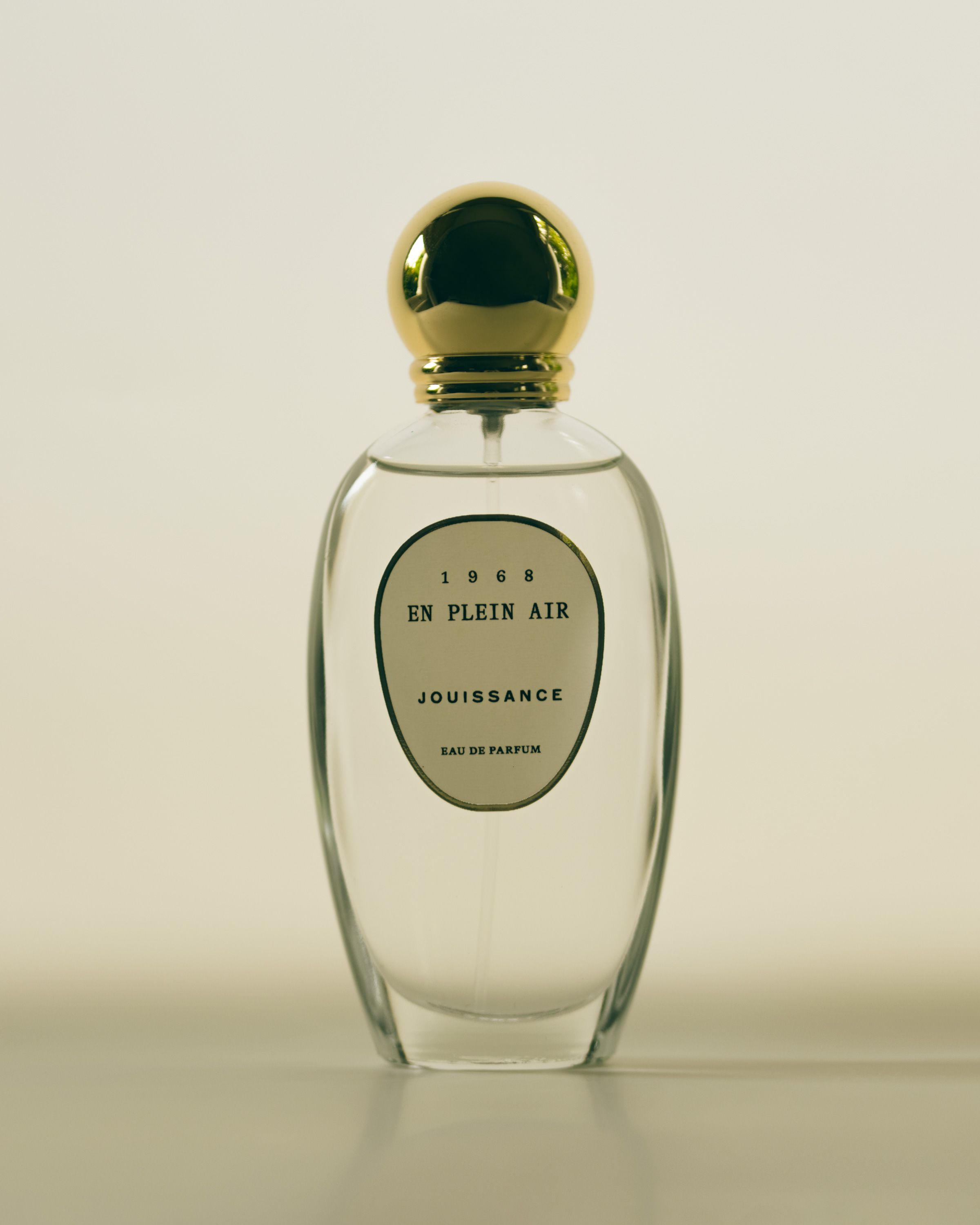 Bottle of En Plein Air by Jouissance, with a simple curved label and circular gold cap